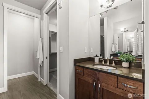 a bathroom with a granite countertop sink a mirror and a shower