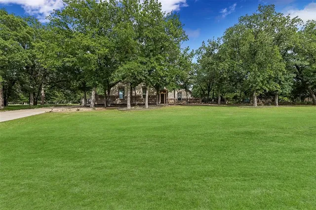a backyard of a house with lots of green space and fountain