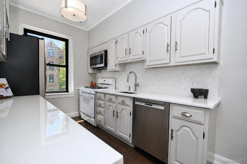 143 Garth Road, Unit 4P Scarsdale, NY 10583 - Photo 8 of 44 Updated Eat-In-Kitchen has Quartz counters and stainless steel appliances.