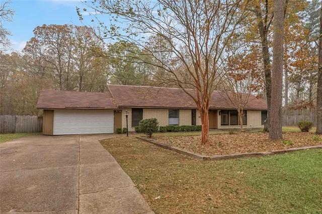 a front view of a house with yard and trees