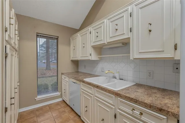 a sink with white cabinets