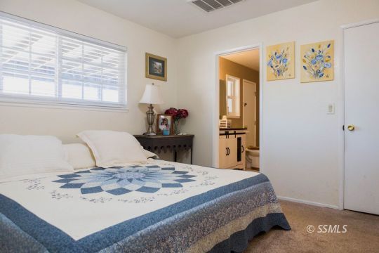 1108 South Allen Street Ridgecrest, CA 93555 - Photo 19 of 34 a bedroom with a bed and wooden floor