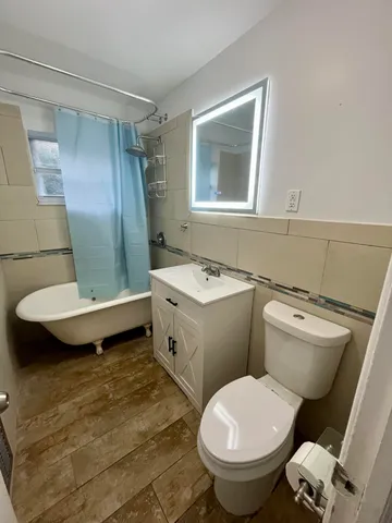 a bathroom with a granite countertop toilet sink and mirror
