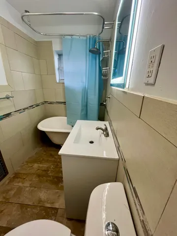 a bathroom with a toilet sink and mirror