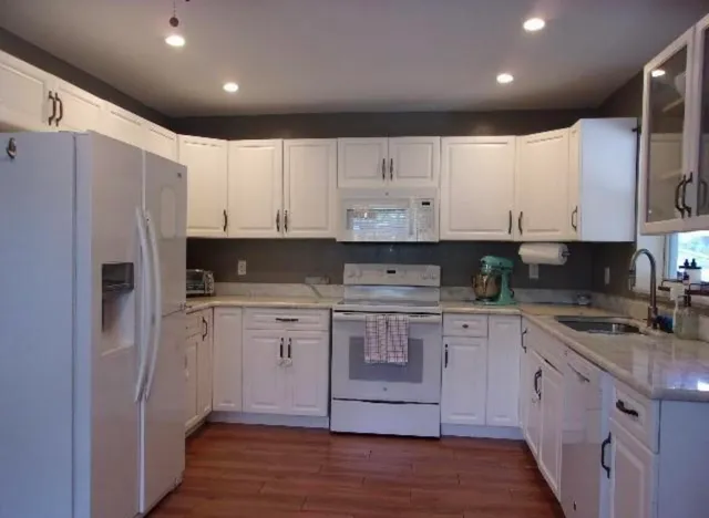 a kitchen with stainless steel appliances granite countertop a refrigerator sink and cabinets