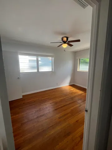 a view of empty room with window and ceiling fan