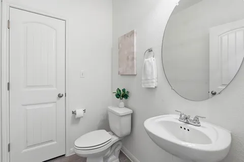 a bathroom with a sink a toilet and a mirror