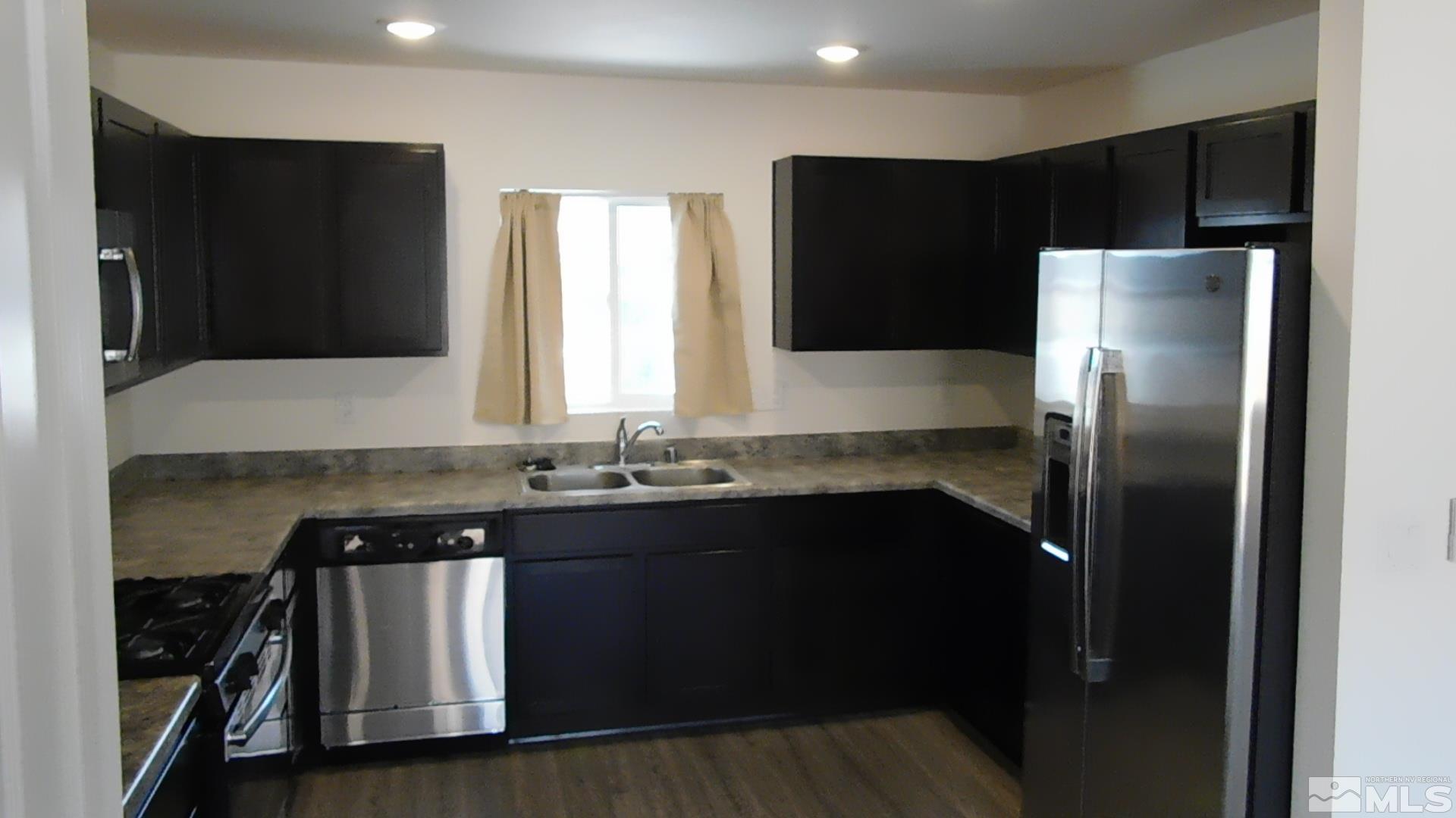 239 Misty Way Dayton, NV 89403 - Photo 3 of 29 a kitchen with a sink and a refrigerator