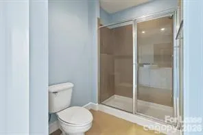 a white toilet next to a glass door