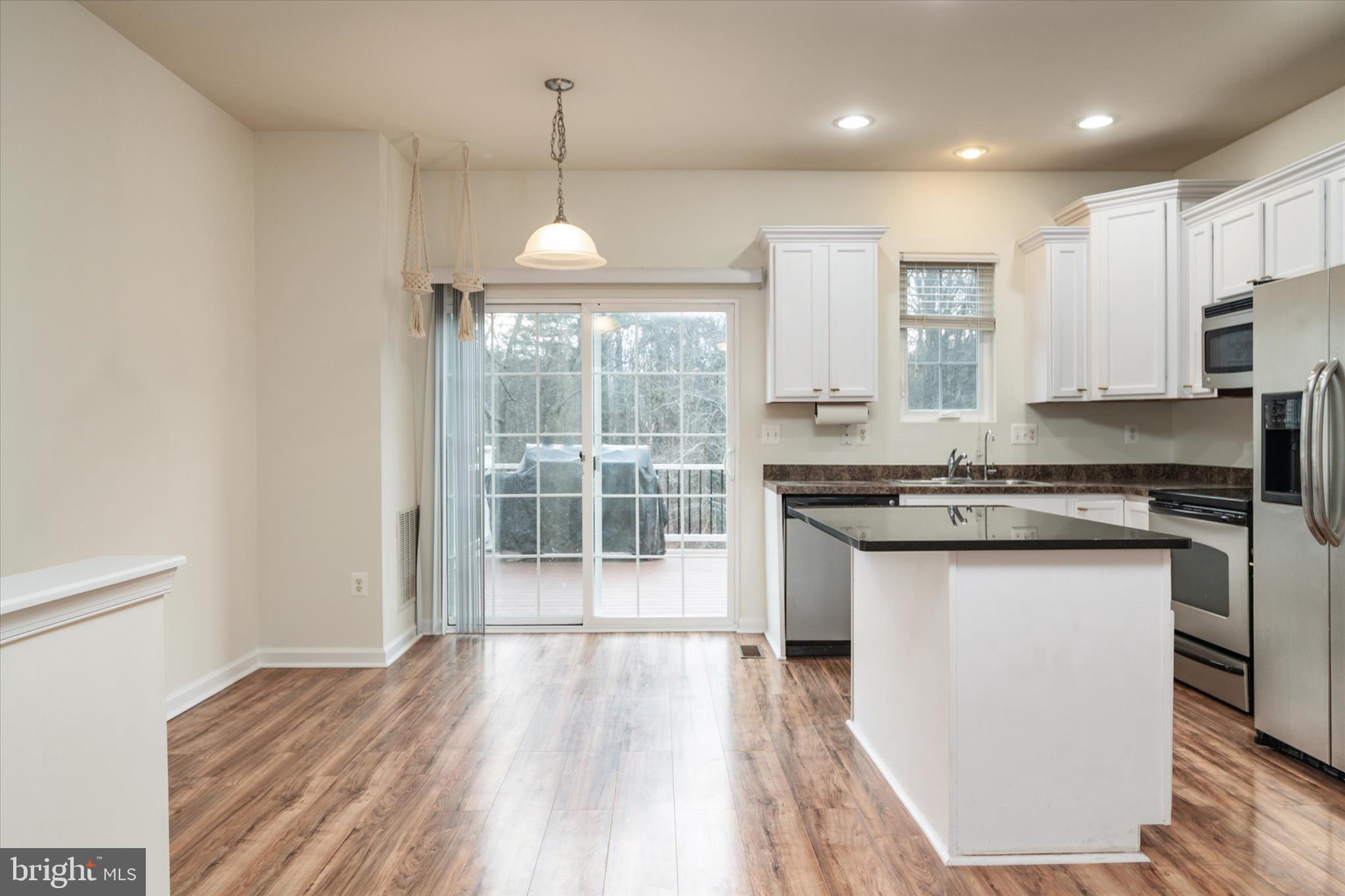 1013 Sithean Way Glen Burnie, MD 21060 - Photo 11 of 35 a kitchen with stainless steel appliances granite countertop a stove and a wooden floors