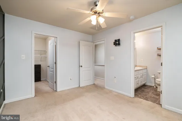 an empty room with closet and a ceiling fan