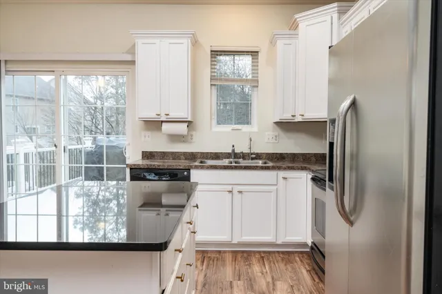 a kitchen with stainless steel appliances granite countertop a stove a sink and a refrigerator