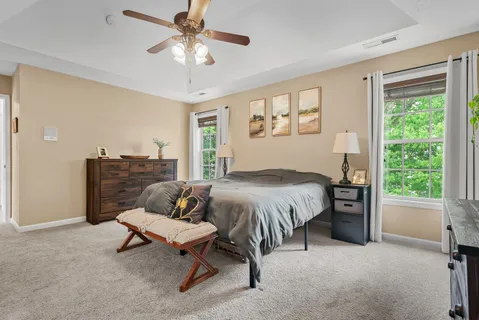 a spacious bedroom with a bed and a chandelier