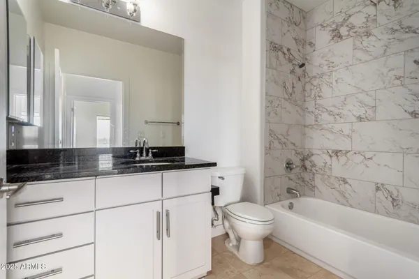 a bathroom with a sink a toilet a mirror and bathtub