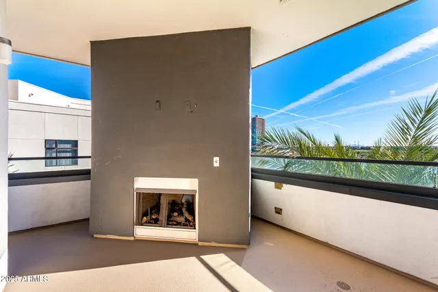 a view of a living room with a floor to ceiling window and kitchen view