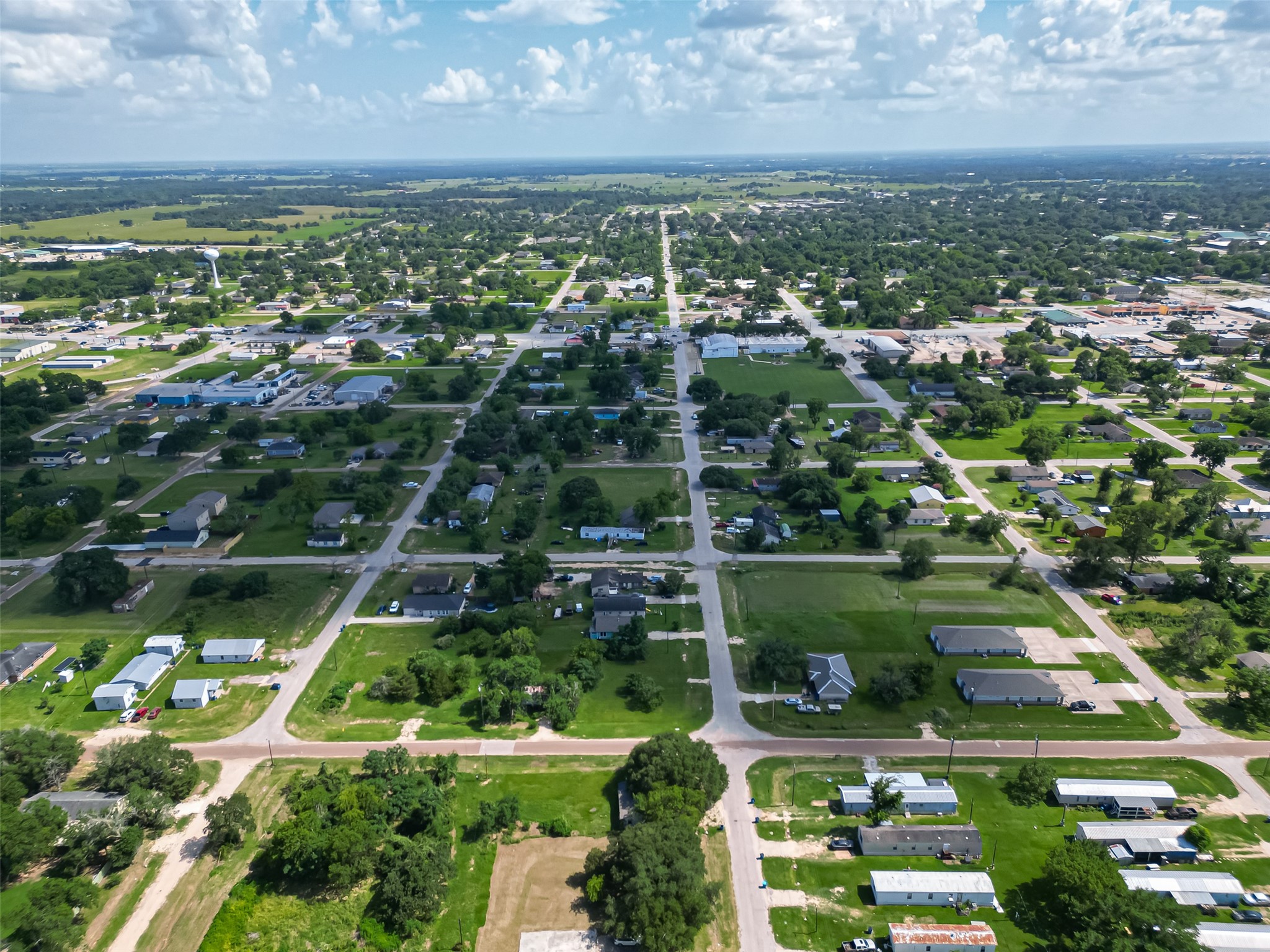 210 5th Street Hempstead, TX 77445 - Photo 30 of 36 an aerial view of residential houses with outdoor space and trees