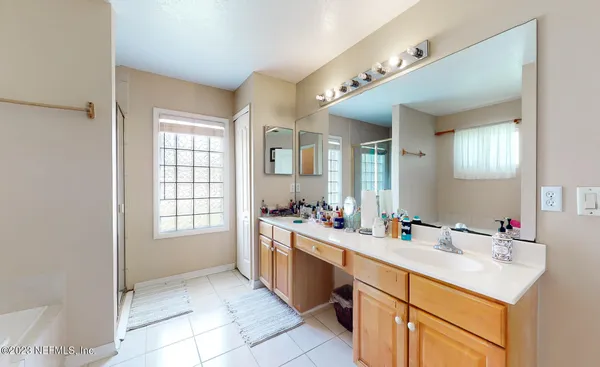 a bathroom with a sink vanity tub and a mirror