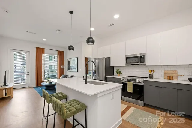 a kitchen with granite countertop a sink appliances and wooden floor