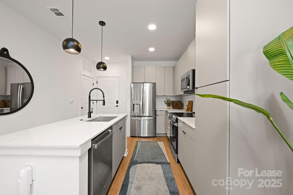 4101 Raleigh Street, Unit B1 Charlotte, NC 28206 - Photo 39 of 48 a kitchen with stainless steel appliances granite countertop a sink a stove and refrigerator