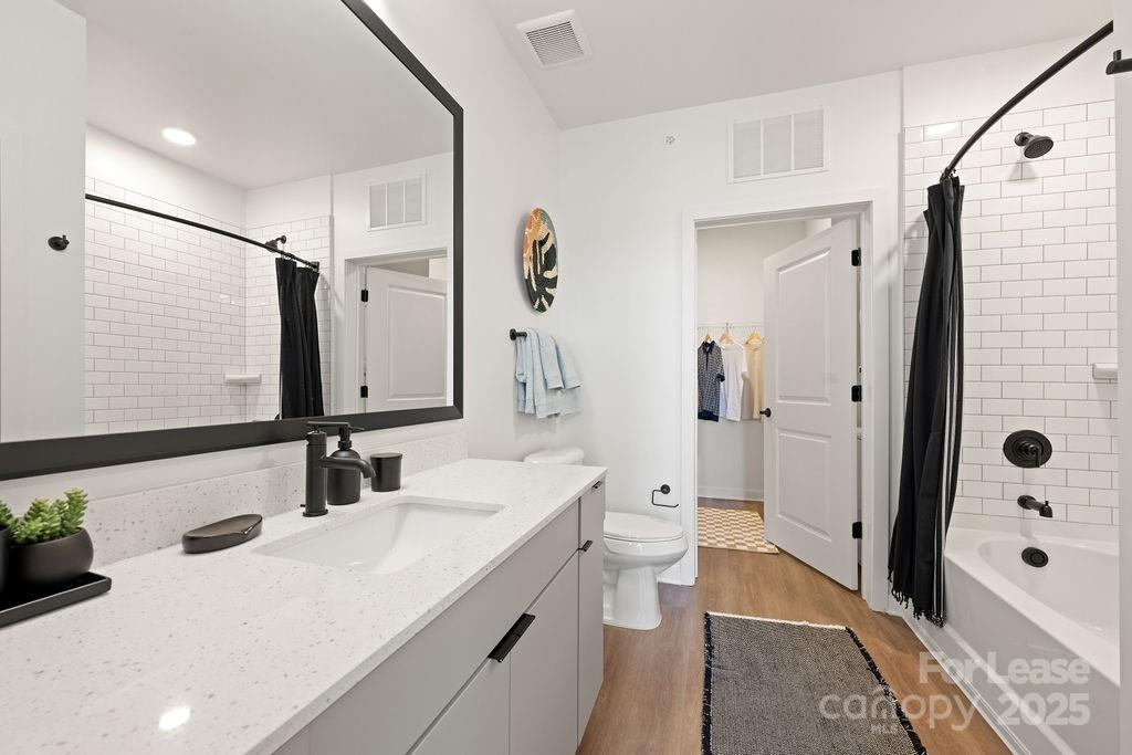 4101 Raleigh Street, Unit B1 Charlotte, NC 28206 - Photo 43 of 48 a bathroom with a double vanity sink toilet mirror and shower