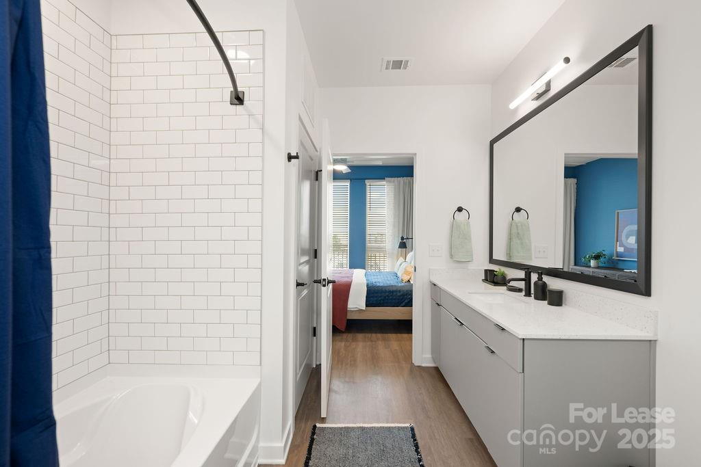 4101 Raleigh Street, Unit B1 Charlotte, NC 28206 - Photo 45 of 48 a bathroom with a bathtub a mirror a double vanity sink and vanity