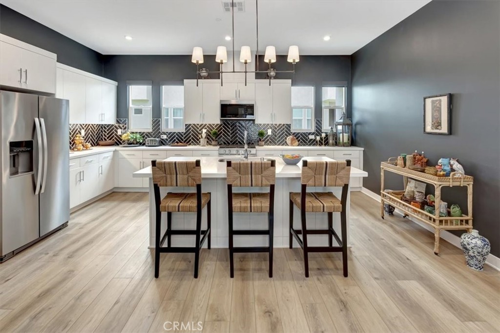 1810 West Bushell Street Anaheim, CA 92805 - Photo 11 of 36 a kitchen with stainless steel appliances kitchen island granite countertop a table chairs and a refrigerator