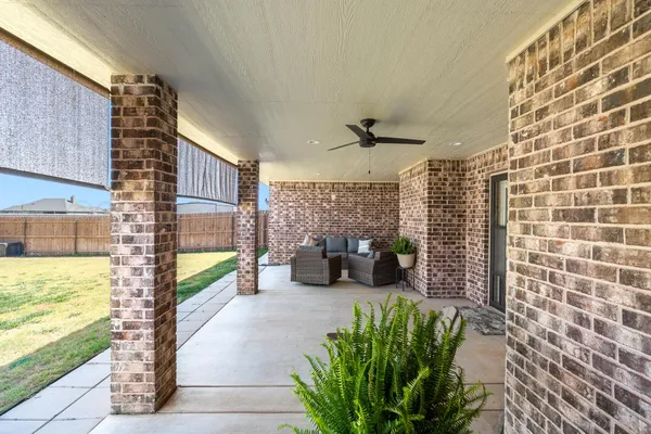 a view of a patio with a dining table and chairs with plants and plants