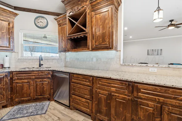 a kitchen with stainless steel appliances wooden cabinets and a wooden floor