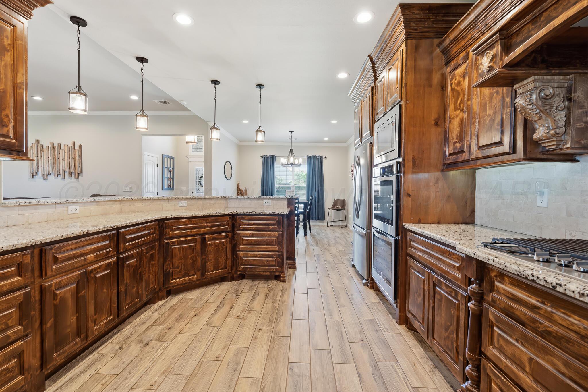9801 Yesterday Amarillo, TX 79119 - Photo 28 of 54 a kitchen with stainless steel appliances granite countertop a stove a sink dishwasher and a oven with wooden floor