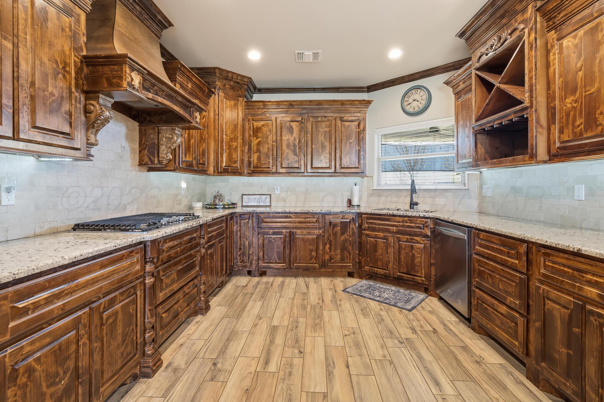 9801 Yesterday Amarillo, TX 79119 - Photo 29 of 54 a kitchen with stainless steel appliances wooden cabinets and a wooden floor