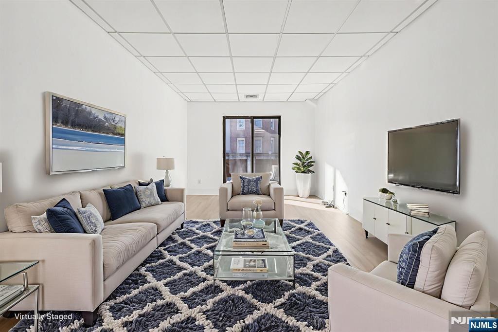 279 Clark Street, Unit A7 Hackensack, NJ 07601 - Photo 13 of 34 a living room with furniture and a flat screen tv