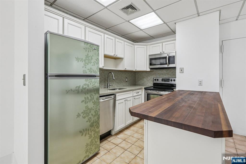 279 Clark Street, Unit A7 Hackensack, NJ 07601 - Photo 15 of 34 a kitchen with stainless steel appliances a refrigerator sink and microwave