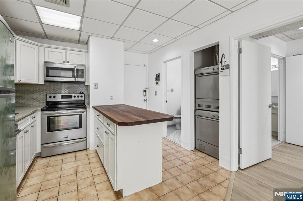 279 Clark Street, Unit A7 Hackensack, NJ 07601 - Photo 18 of 34 a kitchen with stainless steel appliances granite countertop a refrigerator and a stove top oven