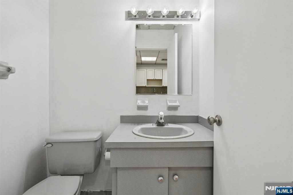 279 Clark Street, Unit A7 Hackensack, NJ 07601 - Photo 21 of 34 a bathroom with a sink toilet and mirror