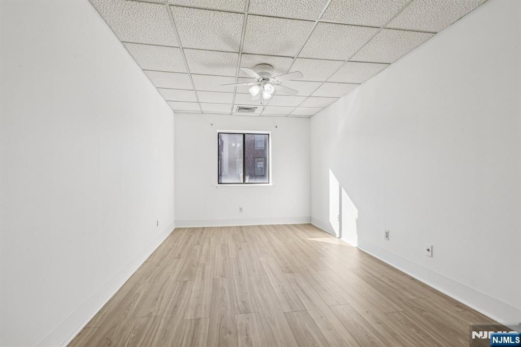 279 Clark Street, Unit A7 Hackensack, NJ 07601 - Photo 23 of 34 an empty room with wooden floor chandelier and window