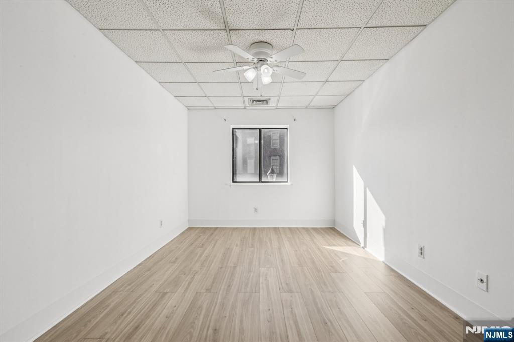 279 Clark Street, Unit A7 Hackensack, NJ 07601 - Photo 24 of 34 an empty room with wooden floor chandelier and windows