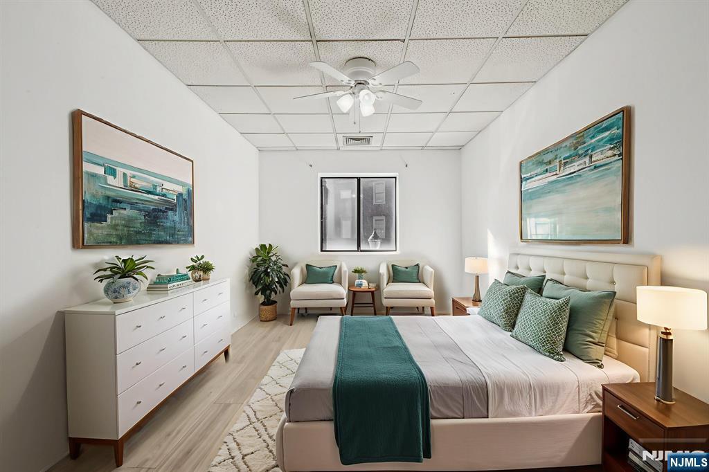 279 Clark Street, Unit A7 Hackensack, NJ 07601 - Photo 27 of 34 a bedroom with a large bed and a chandelier fan