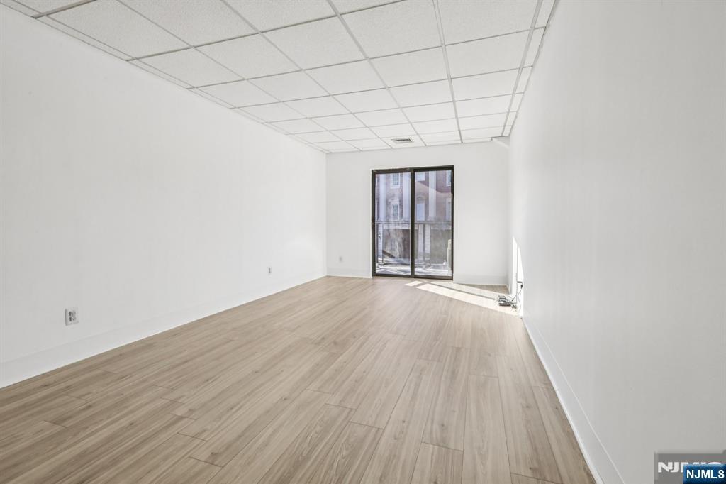 279 Clark Street, Unit A7 Hackensack, NJ 07601 - Photo 9 of 34 wooden floor in an empty room with a window
