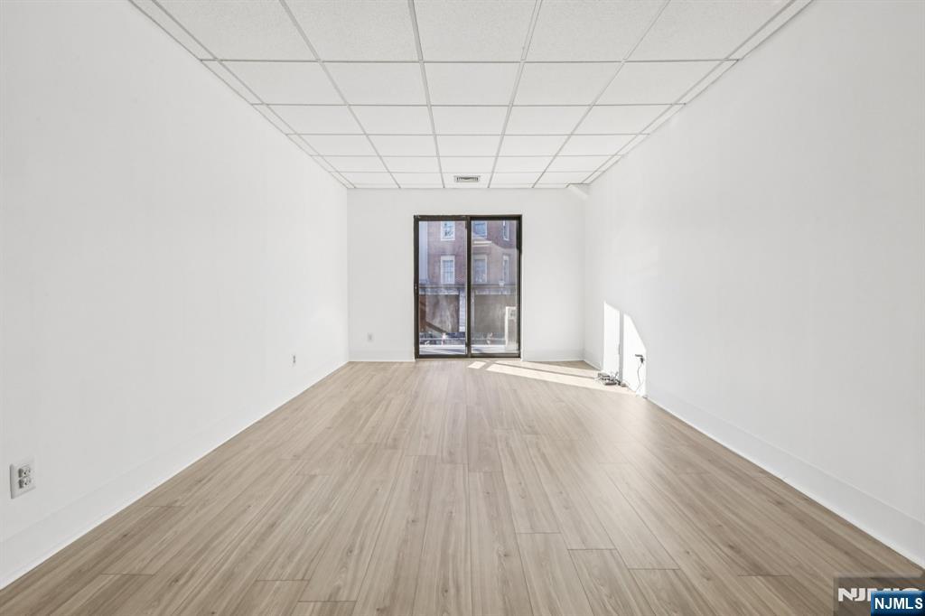 279 Clark Street, Unit A7 Hackensack, NJ 07601 - Photo 10 of 34 an empty room with wooden floor and windows