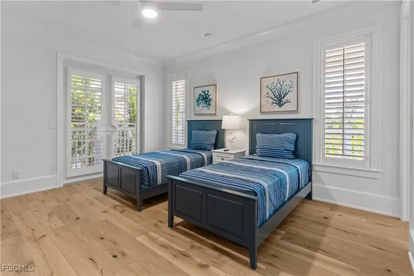 a bedroom with two beds and a large window