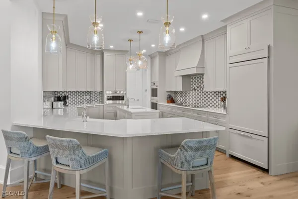 a kitchen with stainless steel appliances granite countertop a table chairs sink and microwave