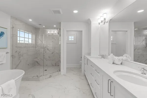 a spacious bathroom with a double vanity sink mirror and shower