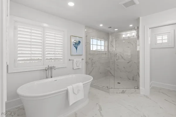 a white bath tub sitting next to a shower