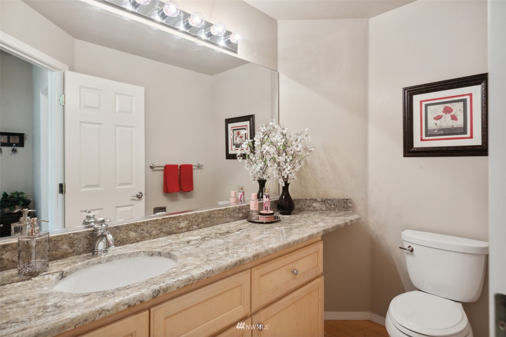 562 Chelan Place Northeast Renton, WA 98059 - Photo 19 of 27 a bathroom with a granite countertop sink mirror vanity and toilet
