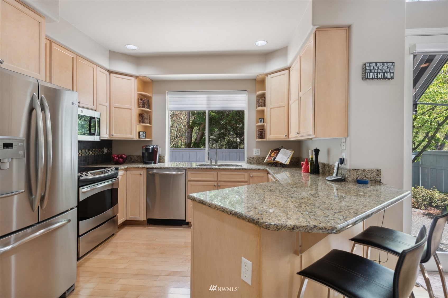 562 Chelan Place Northeast Renton, WA 98059 - Photo 4 of 27 a kitchen with a refrigerator a stove a sink and a granite counter tops with wooden floor