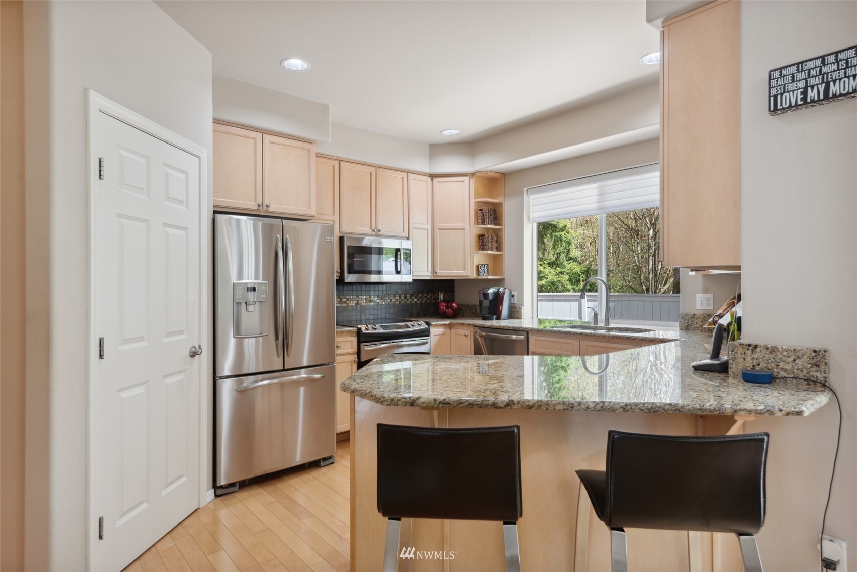 562 Chelan Place Northeast Renton, WA 98059 - Photo 5 of 27 a kitchen with stainless steel appliances granite countertop a refrigerator a stove a sink a microwave a dining table and chairs