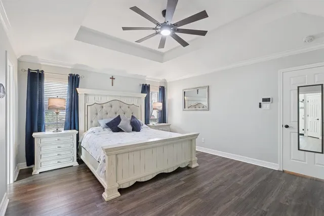 a bedroom with a bed and a large window with wooden floor