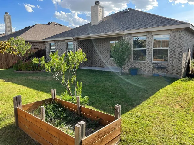 a view of a house with backyard and sitting area