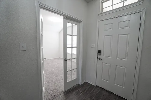 a view of an empty room with wooden floor and closet
