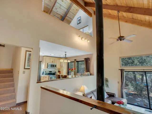 a living room with furniture a flat screen tv and a floor to ceiling window